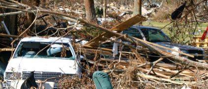 downed trees, damaged cars, and debris after hurricane